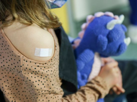 Ein Pflaster klebt auf den Arm eines Mädchens, nachdem es gegen Corona geimpft wurde.