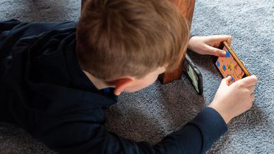 Ein Junge spielt ein Videospiel auf seinem Smartphone.