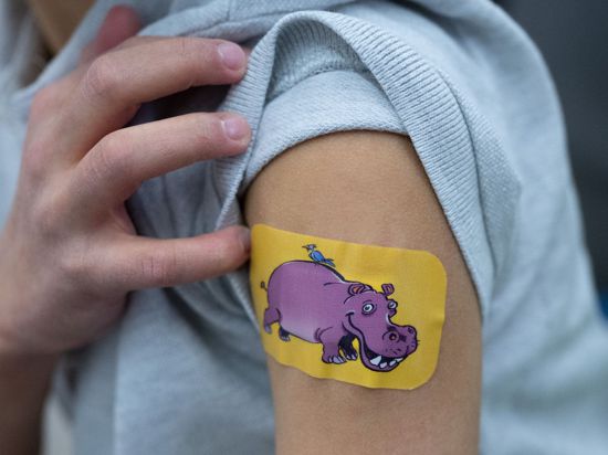 Ein gerade geimpftes Kind hat ein Pflaster mit einem Nilpferd-Motiv auf dem Arm.