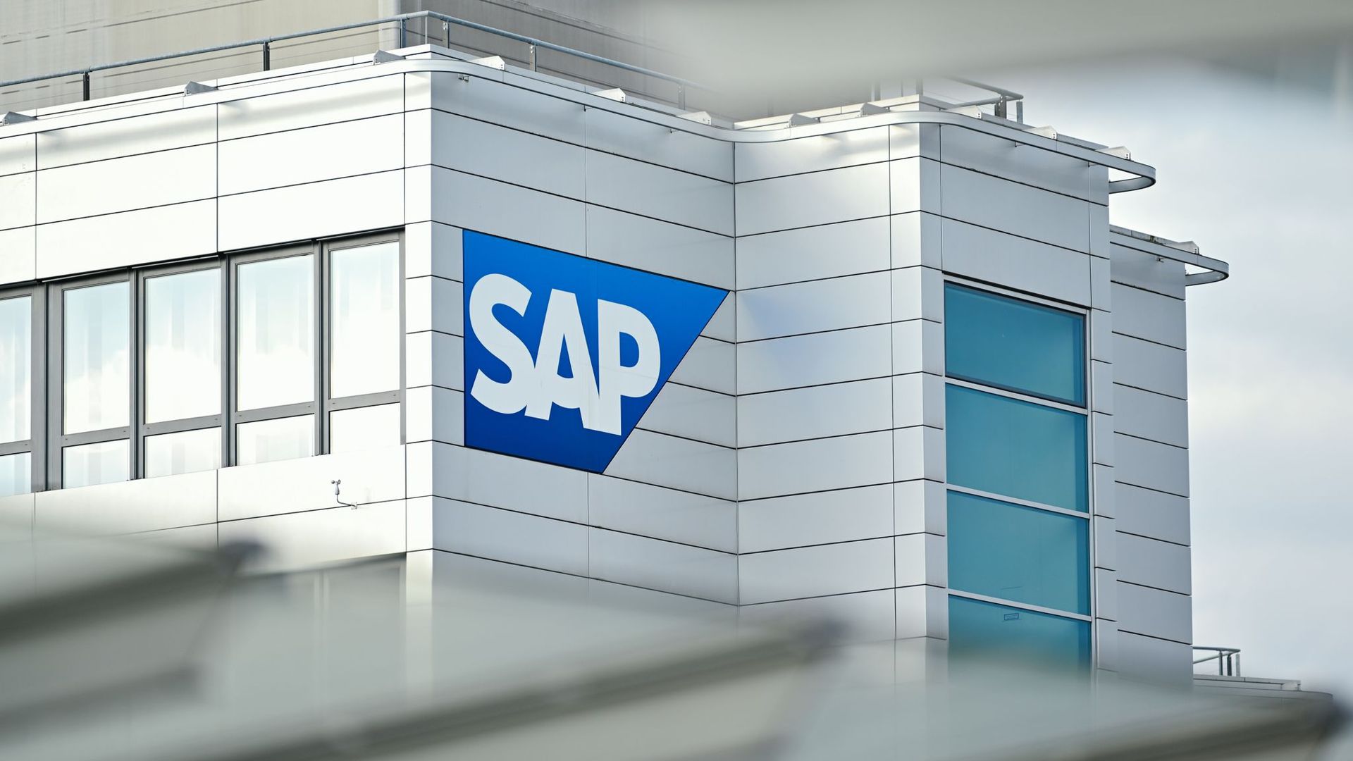 Ein Firmenlogo des Softwarekonzerns SAP ist an einem Firmengebäude angebracht.