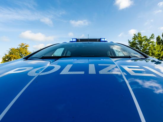 Auf der Motorhaube eines Streifenwagens steht der Schriftzug „Polizei“.