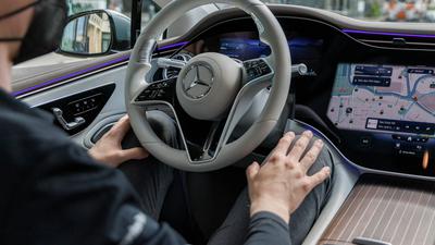 Florian Kunkel, Entwickler bei der Mercedes Benz AG, sitzt in einem fahrenden Mercedes vom Typ EQS 580 4Matic unter Anwendung des Drive Pilots, einer Technologie der Mercedes Benz AG für das Autonome Fahren.