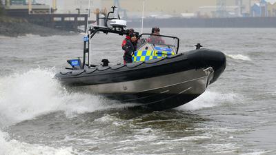 Mitarbeiter der Wasserschutzpolizei fahren in einem Boot auf dem Wasser.