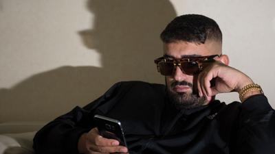 Der Rapper Aykut Anhan, alias Haftbefehl, sitzt  vor einem Interview auf einer Couch.