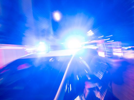 Ein Streifenwagen der Polizei steht mit Blaulicht an einem Einsatzort.