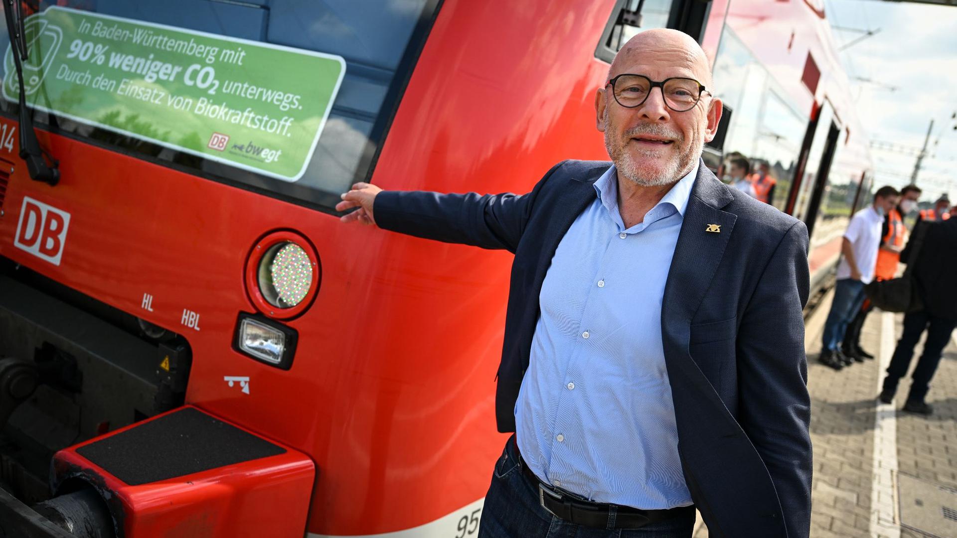 Winfried Hermann, Verkehrsminister von Baden-Württemberg, steht neben einem Zug.