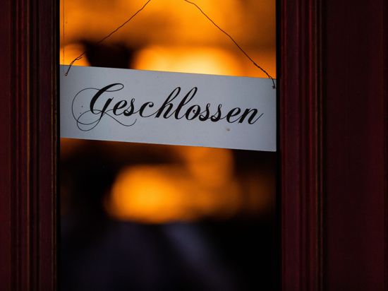 Ein Schild mit der Aufschrift „Geschlossen“ hängt an der Tür eines Restaurants.