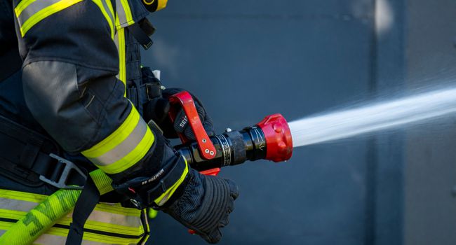 Ein Feuerwehrmann löscht ein Feuer.