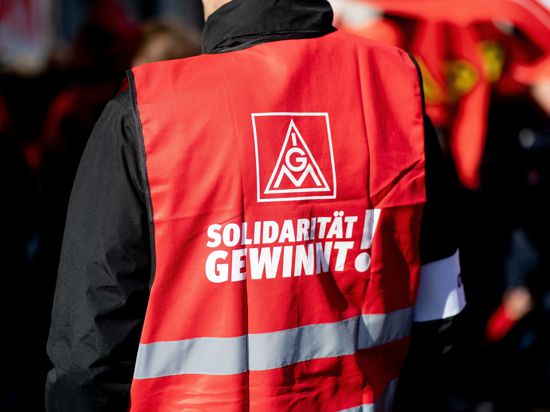 Ein Teilnehmer einer Kundgebung der IG Metall trägt eine Weste mit der Aufschrift „Solidarität gewinnt“.