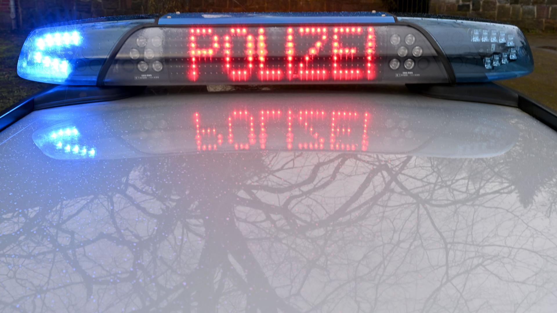 Die Schriftzug „Polizei“ leuchtet auf dem Dach eines Streifenwagens der Polizei.