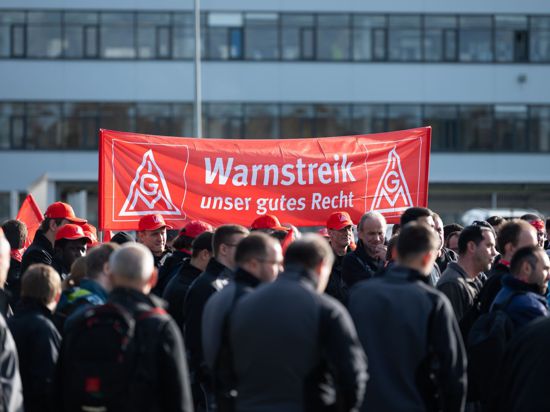 Teilnehmer einer Kundgebung der Gewerkschaft IG Metall halten während eines Warnstreiks in Pfullendorf.