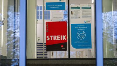 An einer Eingangstür zur Uniklinik weist ein Plakat auf einen Streik hin.