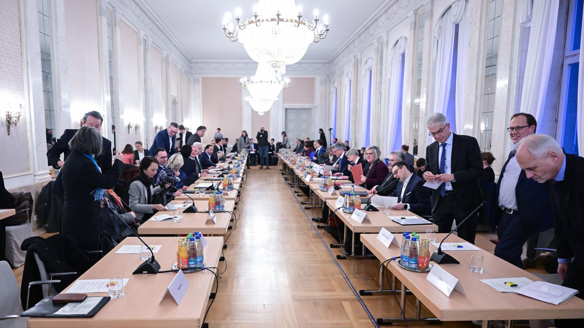 Politiker und Vertreter von Kommunen und Verbänden sitzen bei einem großen Flüchtlings-Gipfel.