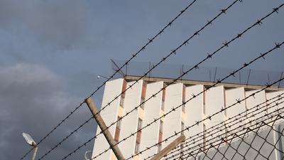 Ein Stacheldrahtzaun umzäunt das Gelände einer Justizvollzugsanstalt