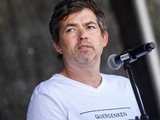 Michael Ballweg, Initiator der Initiative „Querdenken“, steht vor einem Mikrophon.