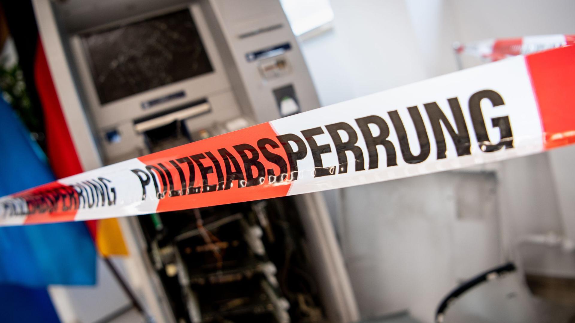 Ein gesprengter Geldautomat ist hinter einem Flatterband mit der Aufschrift „Polizeiabsperrung“ zu sehen.