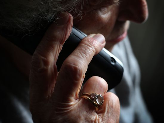 Eine ältere Dame telefoniert mit einem Festnetztelefon.