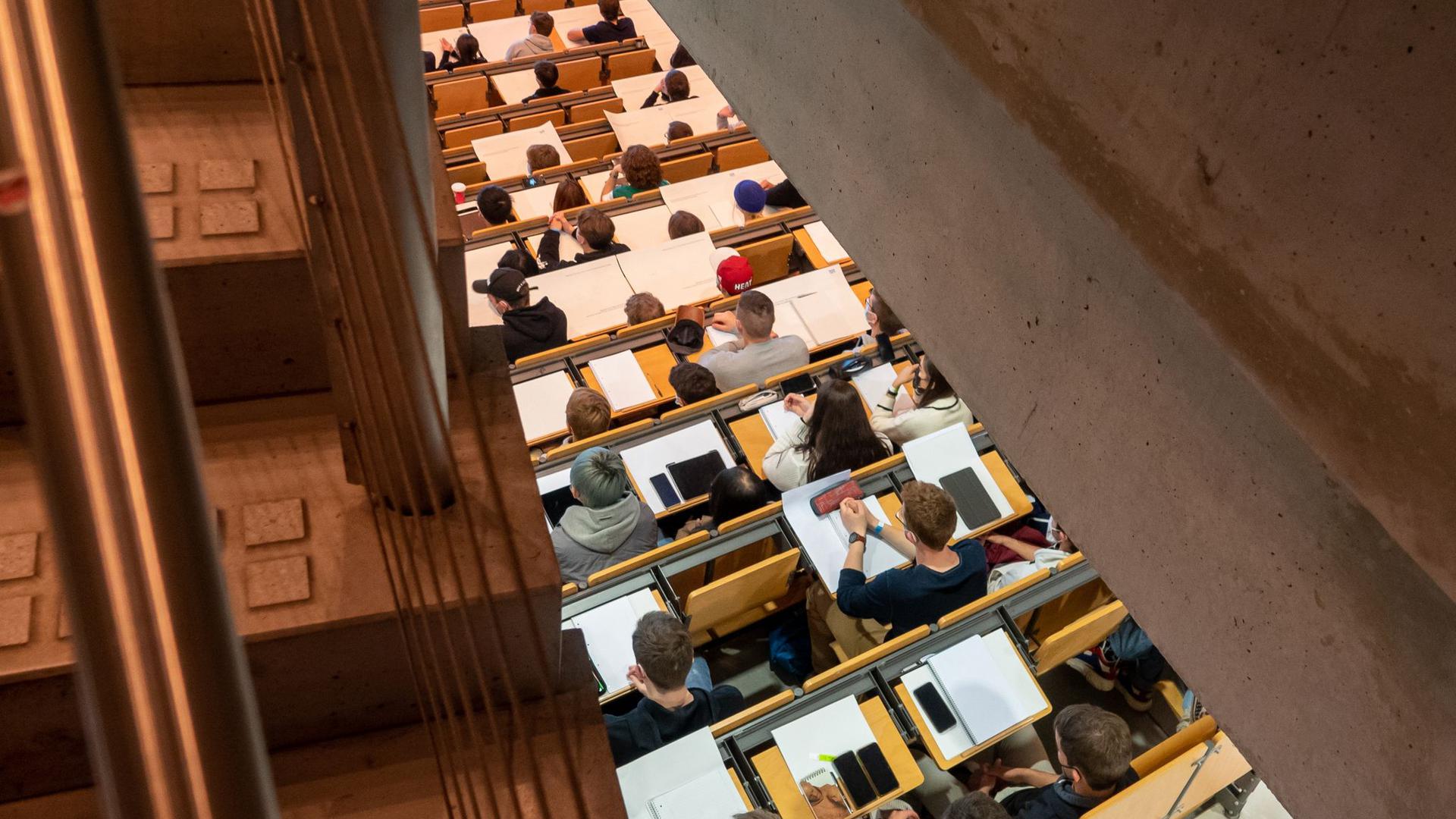 Studierende nehmen im Hörsaal an einer Vorlesung teil.