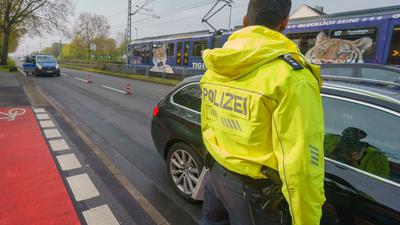 Ein Polizeibeamter kontrolliert ein Fahrzeug auf der Heerstraße nach einer Geschwindigkeitsmessung.