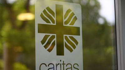 Das Caritas Logo auf einer Glastür.