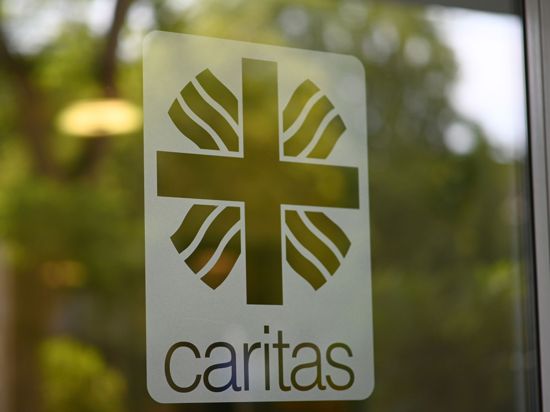 Das Caritas Logo auf einer Glastür.
