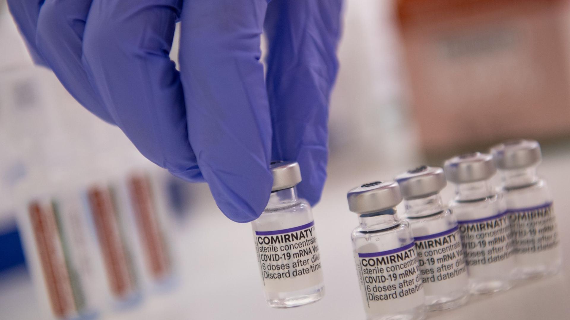 Eine Arzthelferin hält eine Ampulle mit dem Corona-Impfstoff von Biontech/Pfizer in der Hand.