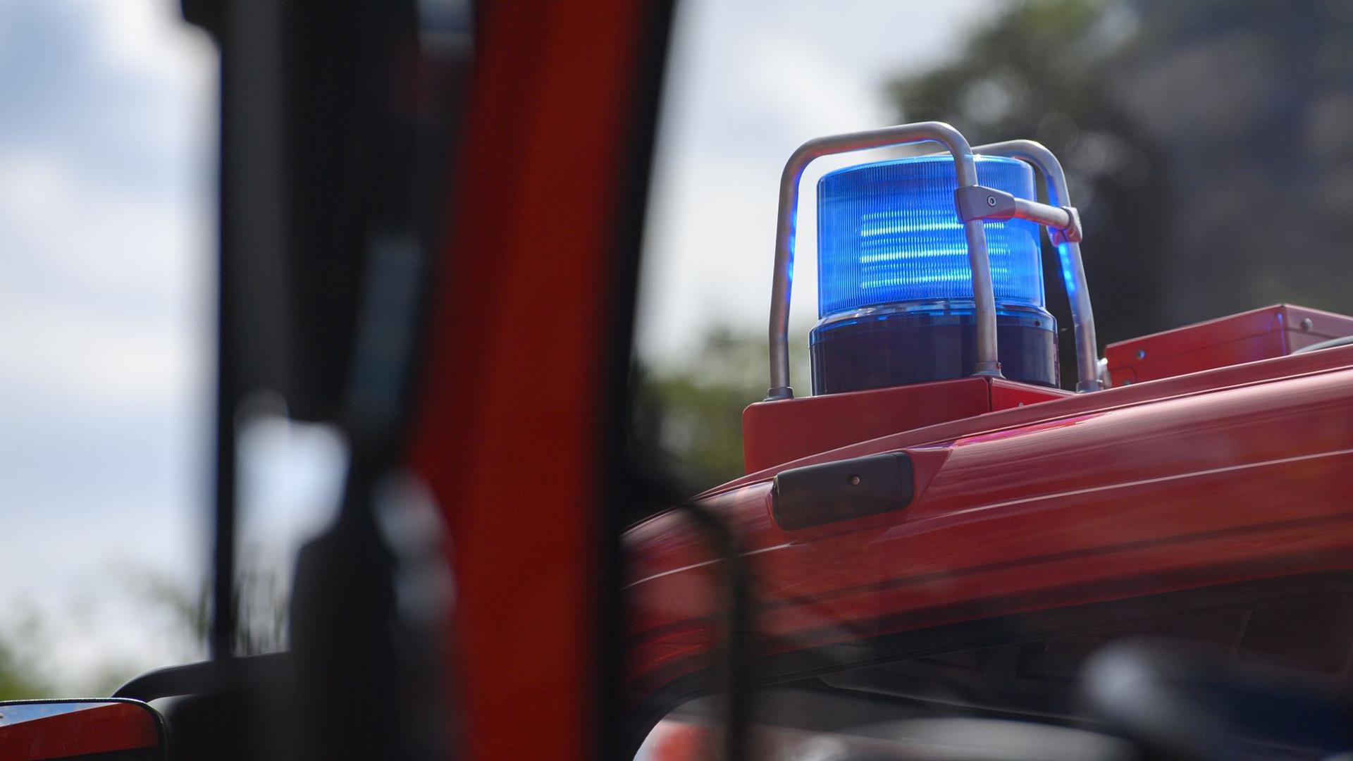 Ein Blaulicht leuchtet auf dem Dach eines Einsatzfahrzeugs der Feuerwehr.