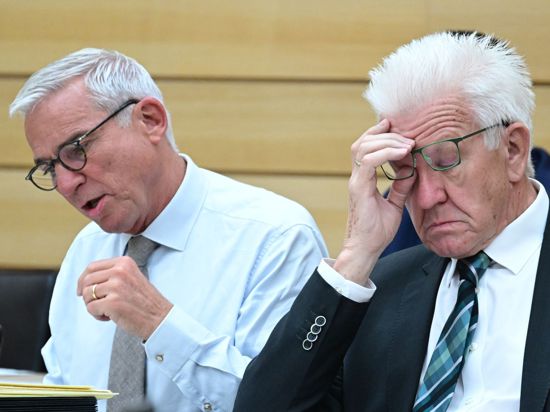 Innenminister Strobl (CDU, l) und Ministerpräsident Winfried Kretschmann (Grüne) nehmen an einer Landtagssitzung teil.