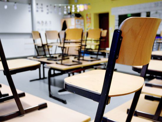 Stühle stehen in einem Klassenzimmer in einer Grundschule auf den Tischen.