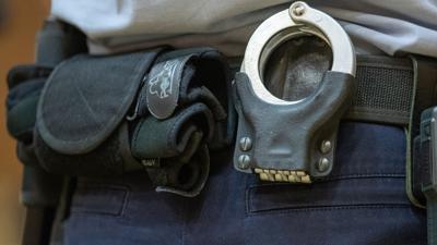 Handschellen stecken in der Gürtelhalterung eines Justizbeamten.