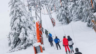 Wintersportler lassen sich von einem Schlepplift einen Skihang hinaufziehen.