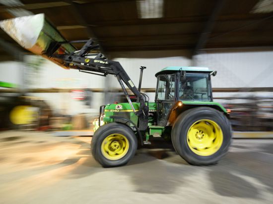 Ein Landwirt fährt mit seinem Radlader in eine Fahrzeughalle. Bayern stellt sich gegen Kürzungen bei Agrarsubventionen.