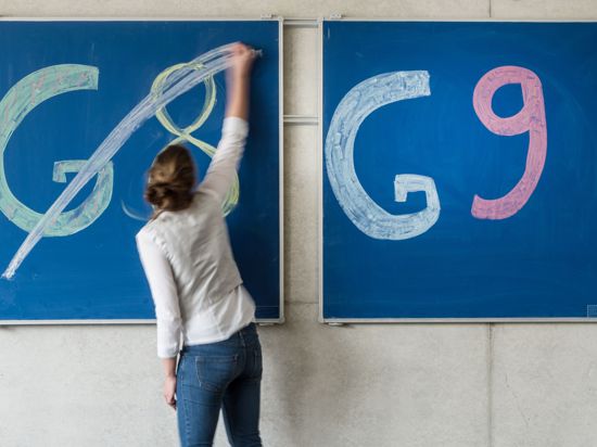 Eine Schülerin der Oberstufe streicht an einem Gymnasium den Schriftzug „G8“ an einer Tafel durch.