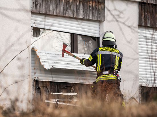Ein Feuerwehrmann entfernt einen Rollladen an einer Doppelhaushälfte, in der sich ein 62-jähriger Bewohner verschanzt hatte.