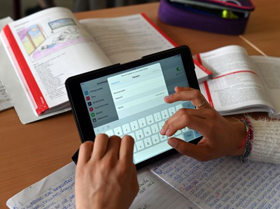 Realschüler einer zehnten Klasse einer Gemeinschaftsschule arbeiten in einer Unterrichtsstunde mit Tablets.