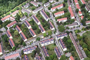 Luftbild, aus einem Flugzeug aufgenommen, von Häusern auf denen Solaranlagen angebracht sind.