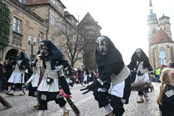 Als Hexen verkleidete Narren laufen beim Fastnachtsumzug in der Stuttgarter Innenstadt über den Schillerplatz.