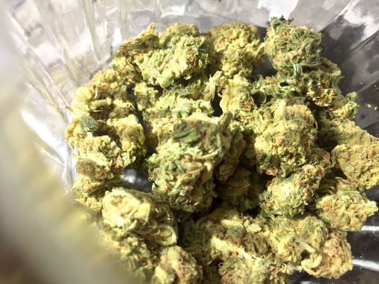 Cannabisblüten liegen in einem Glas.