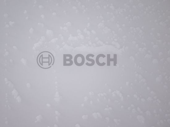 Der Bosch-Schriftzug an einer Wärmepumpe ist in einer Klimakammer von Eis bedeckt.