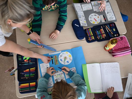 Schüler einer Grundschule arbeiten in einem Klassenzimmer in ihren Heften.