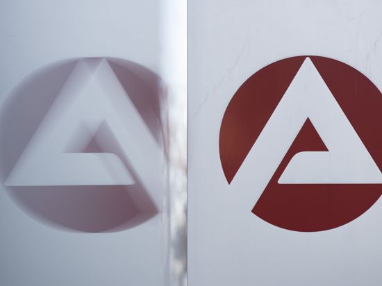 Das Logo der Bundesagentur für Arbeit spiegelt sich in einer Scheibe.