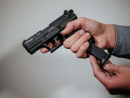 Ein Mann lädt eine Schreckschuss-Pistole „Walther P22“ mit einem Magazin.