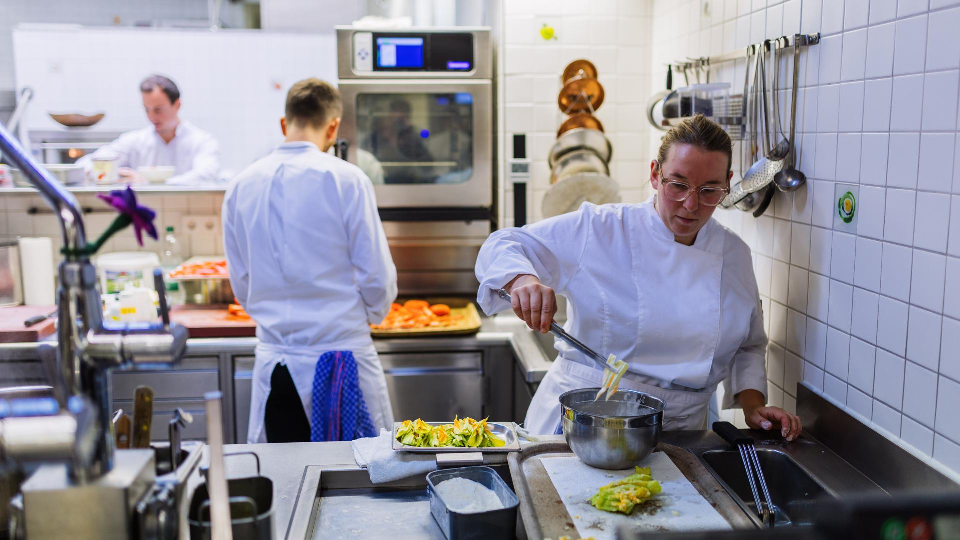 Ein Koch und eine Köchin stehen in der Küche des Zwei-Sterne-Restaurants Hirschen und bereiten den abendlichen Betrieb vor.