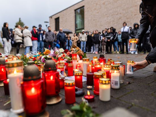 ARCHIV – 10.11.2023, Baden-Württemberg, Offenburg: Rund 200 trauernde Menschen stehen während einer stillen Gedenkveranstaltung rund um Blumen und Kerzen, die vor einer Schule liegen. Tags zuvor hatte in einer Offenburger Schule ein Schüler einen anderen Schüler erschossen, das Opfer erlag später seinen Verletzungen. Foto: Philipp von Ditfurth/dpa/Philipp von Ditfurth/dpa +++ dpa-Bildfunk +++