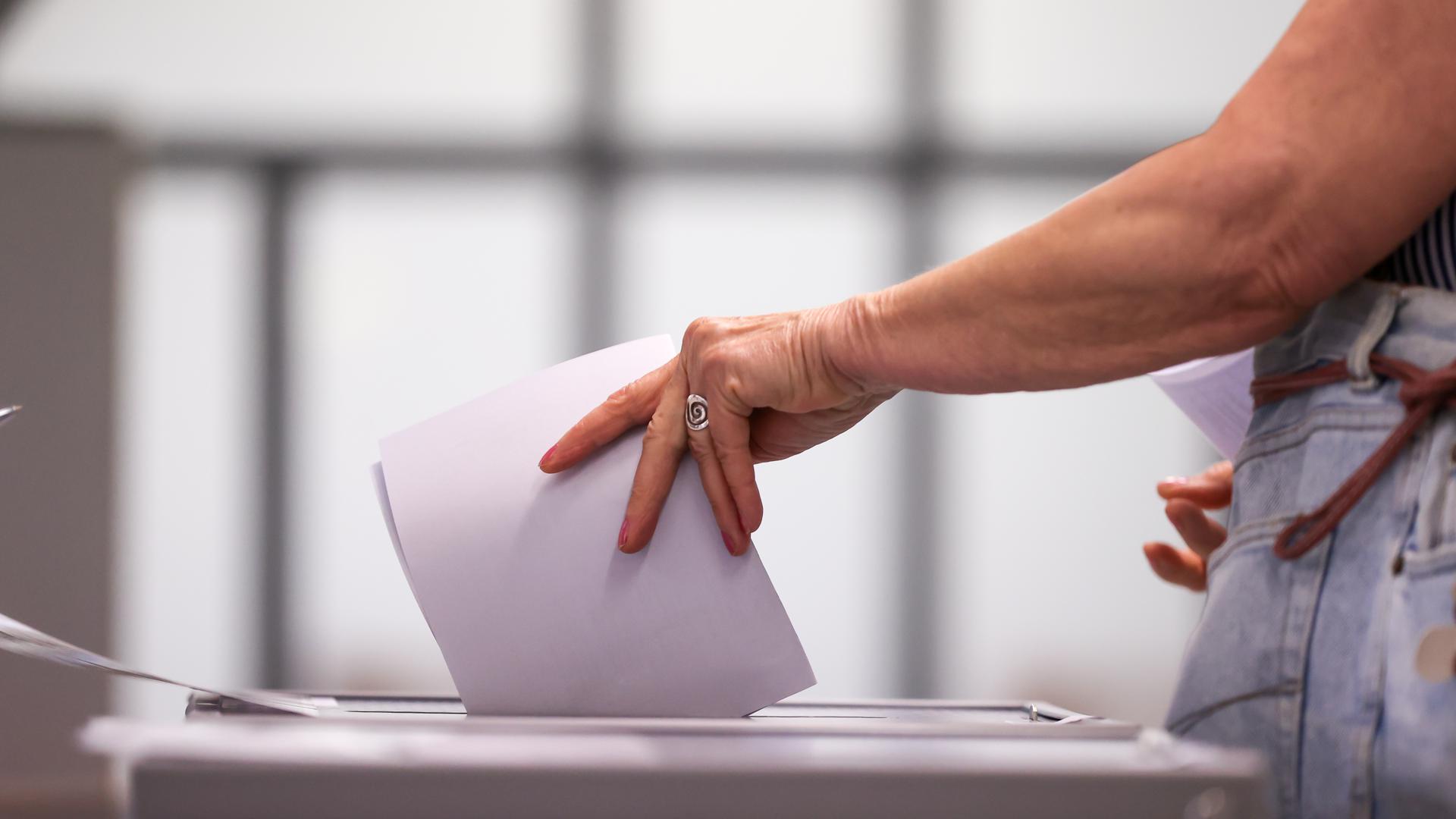 Eine Frau wirft ihren Stimmzettel in eine Urne in einem Wahllokal