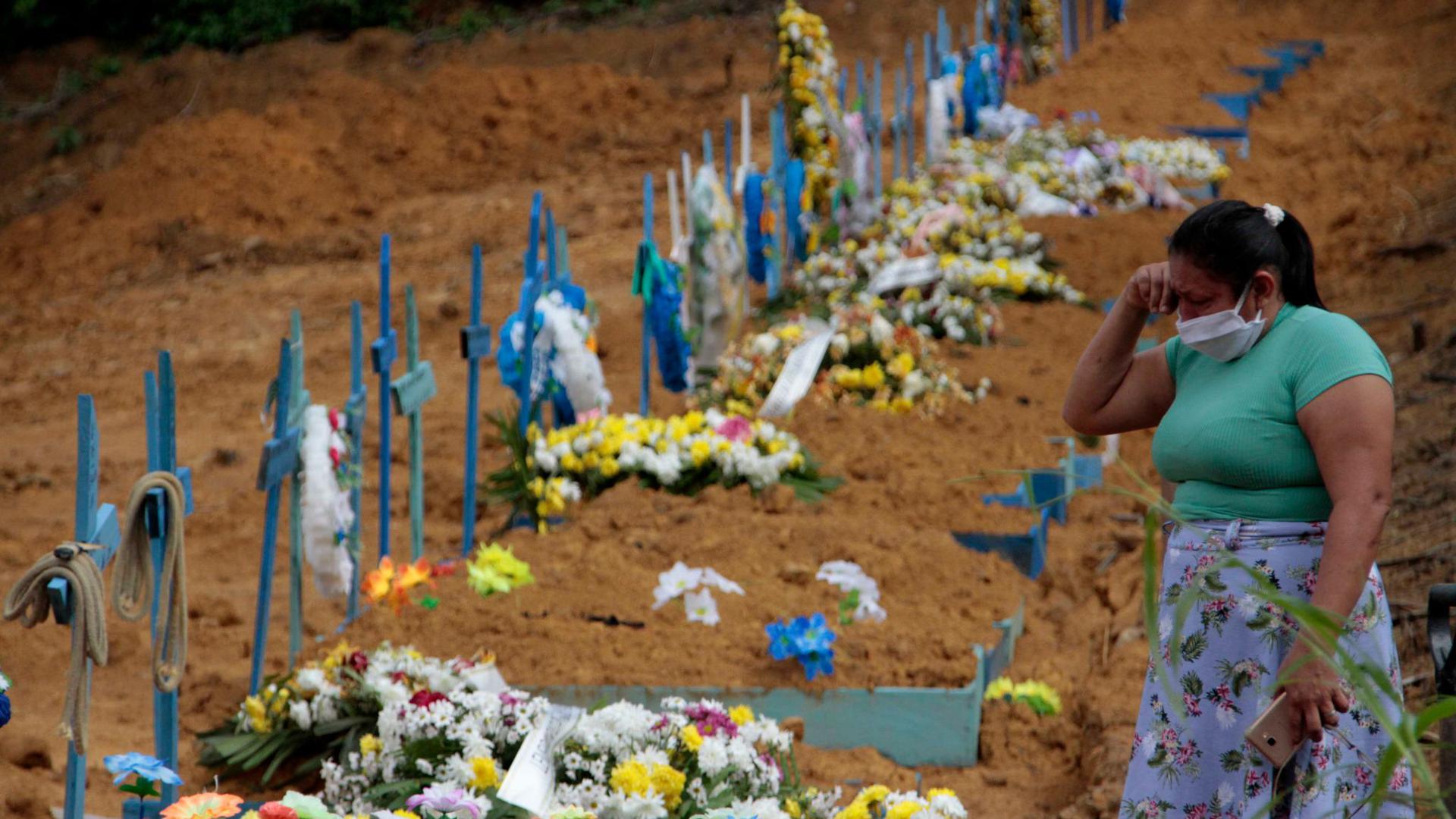 Eine Frau trauert an einem Grab auf einem Friedhof in Manaus.
