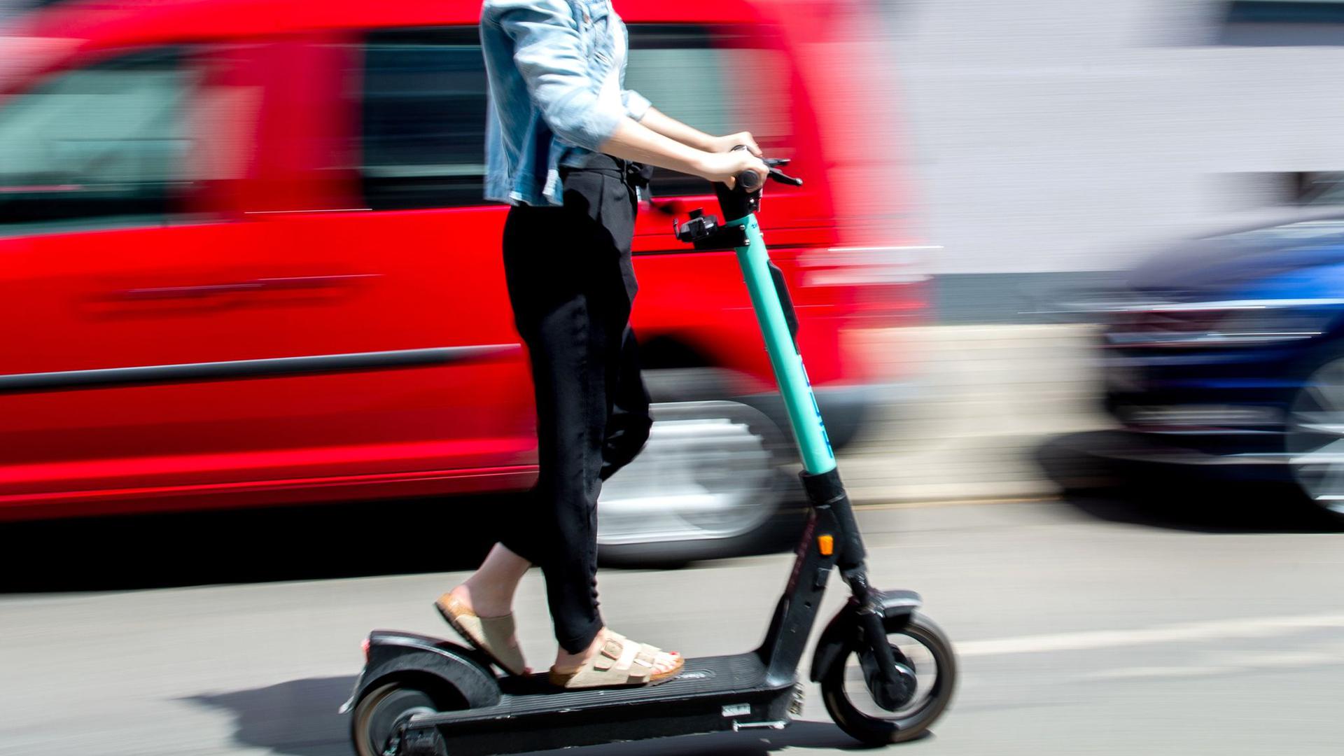 Eine junge Frau unterwegs mit einem E-Scooter in Hannover.