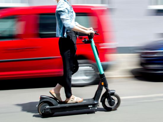 Eine junge Frau unterwegs mit einem E-Scooter in Hannover.