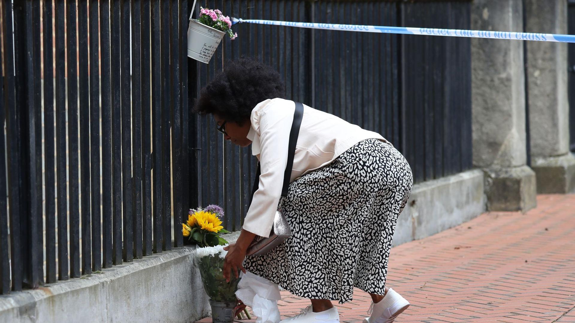 Eine Frau legt zum Gedenken an die Opfer im Stadtzentrum von Reading Blumen nieder.