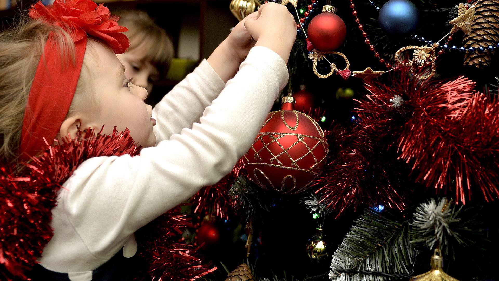 epa04538349 Zosia and her sister Zuzia (back, partially hidden) decorate the Christmas tree at their family house in Zurawica, Poland, 22 December 2014. EPA/DAREK DELMANOWICZ POLAND OUT ++ +++ dpa-Bildfunk +++